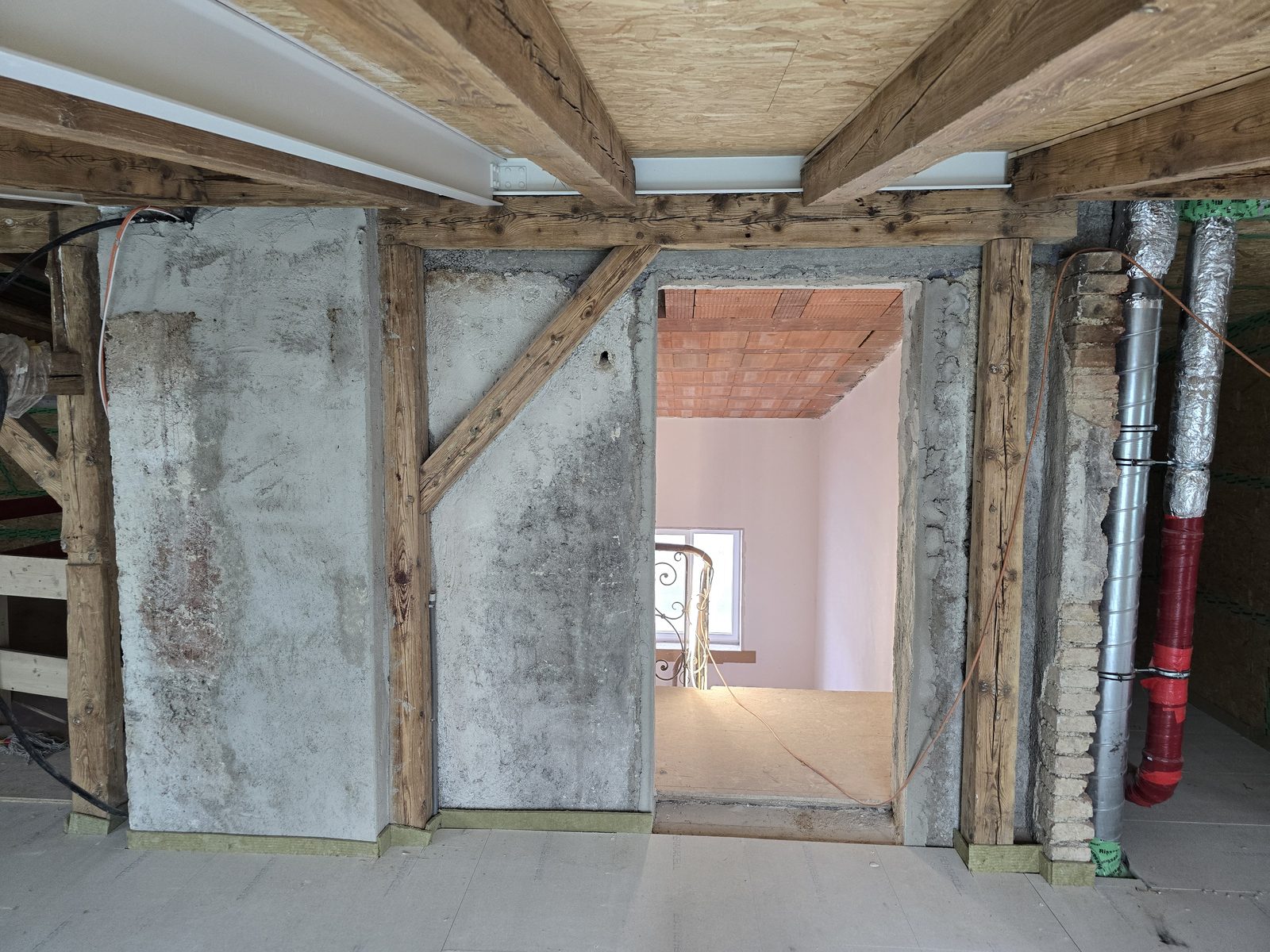 Dachgeschoss im Rohbau mit Fachwerk, Holzbalken und Durchgang
