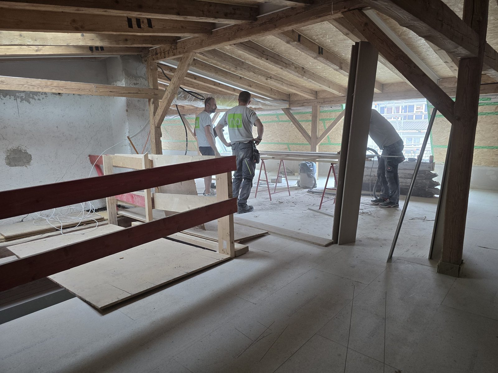 Handwerker arbeiten im Dachstuhl am Trockenbau